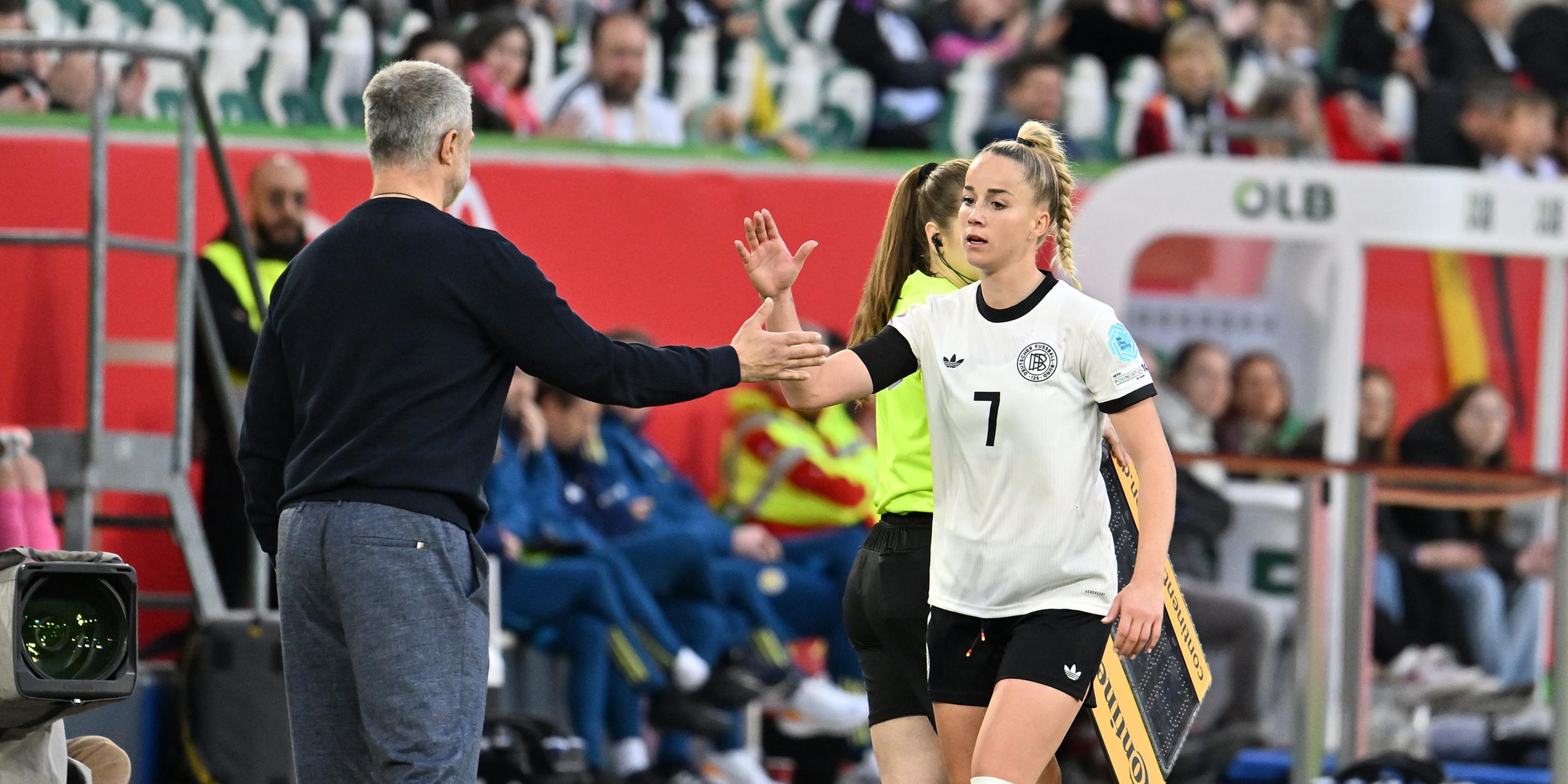 Während des Länderspiels Deutschland gegen Schottland am 08.04.2025 klatscht Deutschlands Giulia Gwinn bei ihrer Auswechselung mit Deutschlands Trainer Christian Wück ab.