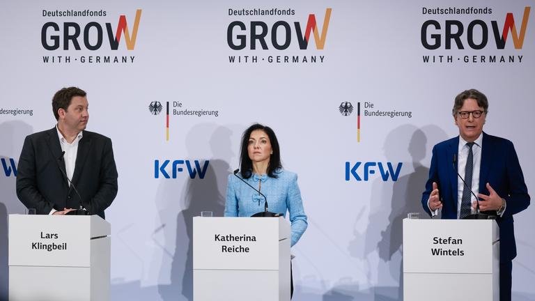 Stefan Wintels (R) gestures as he speaks next to German Economy Minister Katherina Reiche (C) and German Finance Minister Lars Klingbeil (L) during a press conference