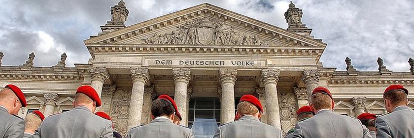Deutsche Soldaten stehen mit dem Rücken zur Kamera vor dem Reichstag.