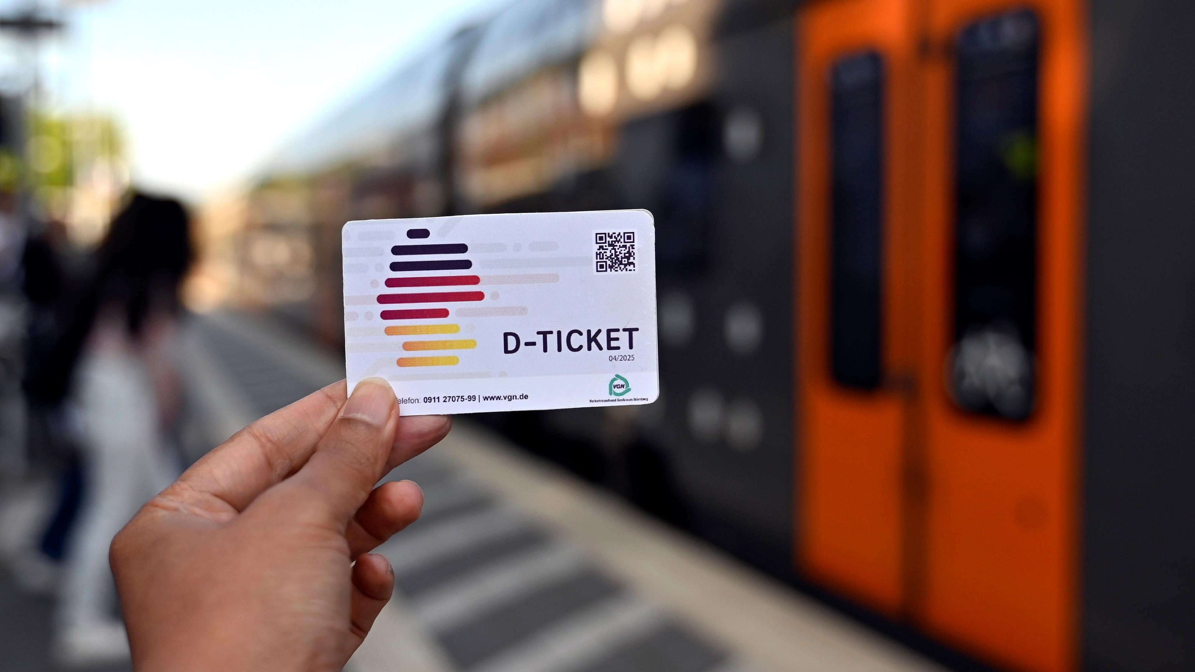 Eine Person hält das Deutschlandticket in der Hand.