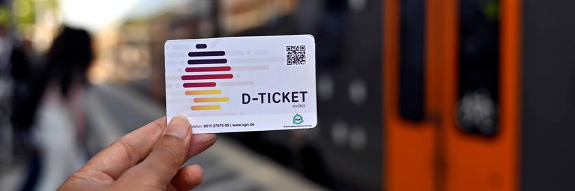 Eine Person hält das Deutschlandticket in der Hand.