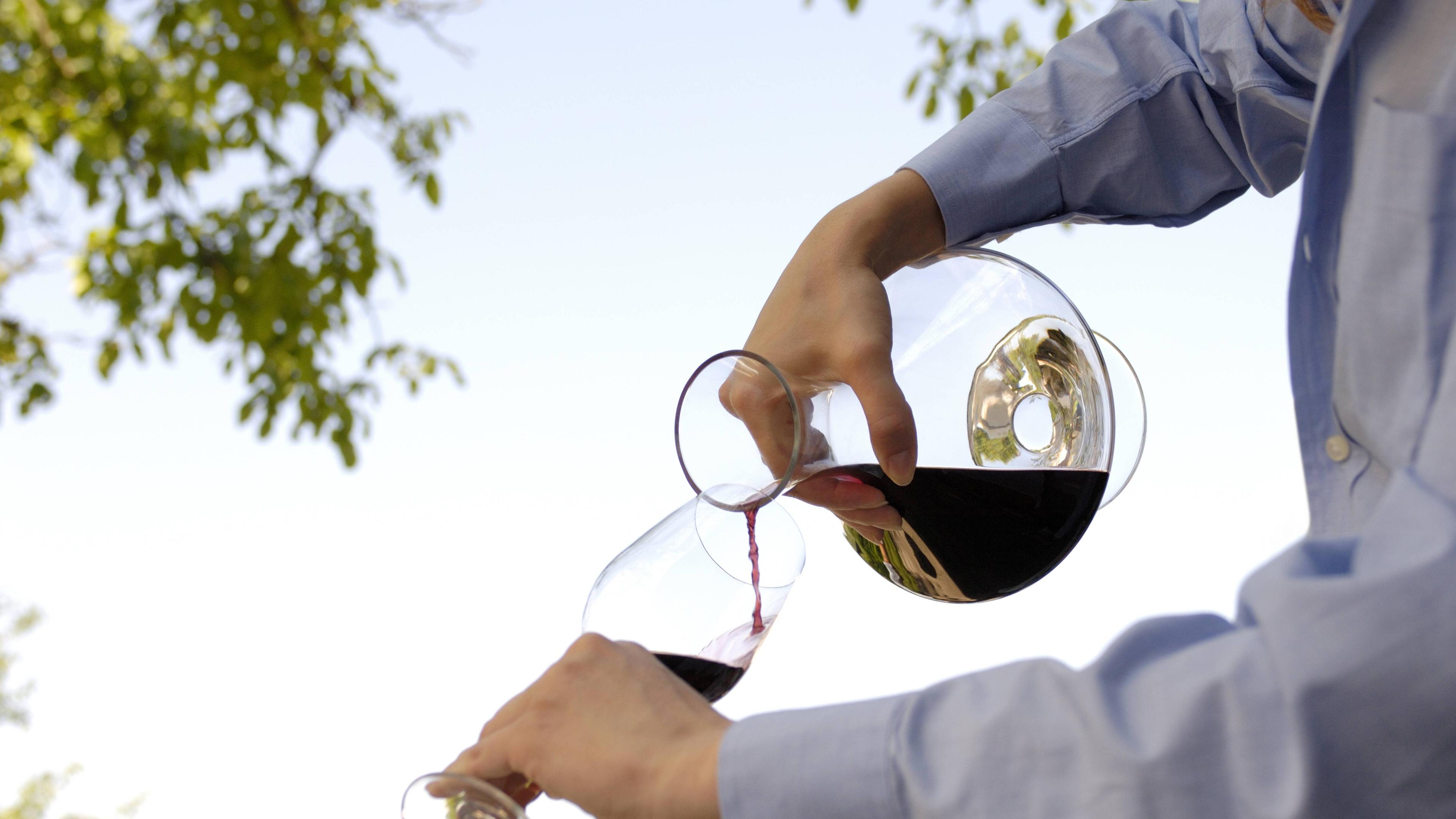 Wein aus Dekantierkaraffe wird in Wein-Glas eingegossen