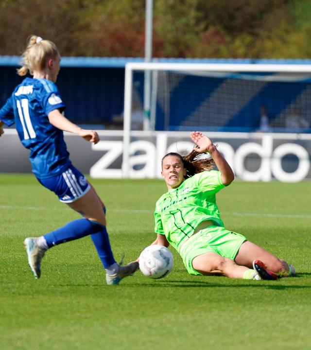 Karla Brinkmann (17, SGS Essen) setzt im Duell mit Jolina Opladen (11, FC Schalke 04) im Parkstadion in Gelsenkirchen zu einer Grätsche an.