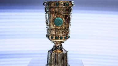 Die goldene DFB-Pokal-Trophäe steht auf einem Podest.