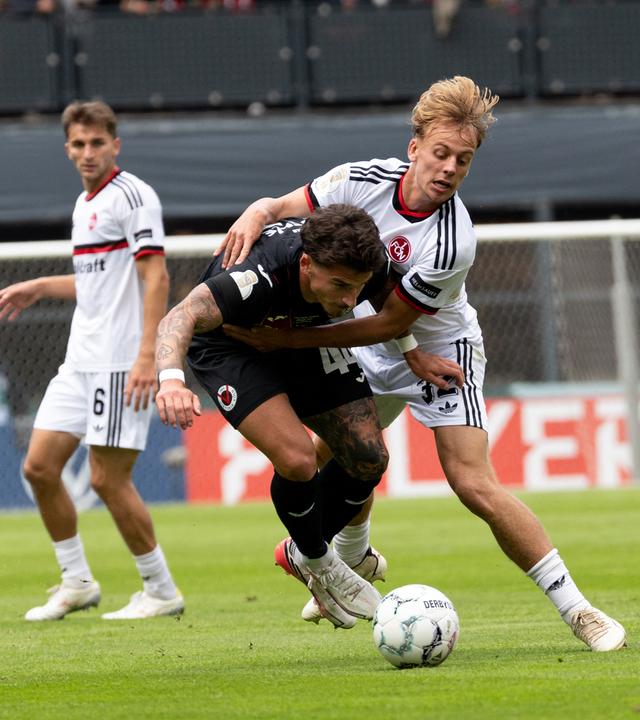 Viktoria Kölns Niklas Castelle im Zweikampf mit 1. FC Nürnbergs Tim Janisch (l-r) am 22.08.2026 in Köln. 