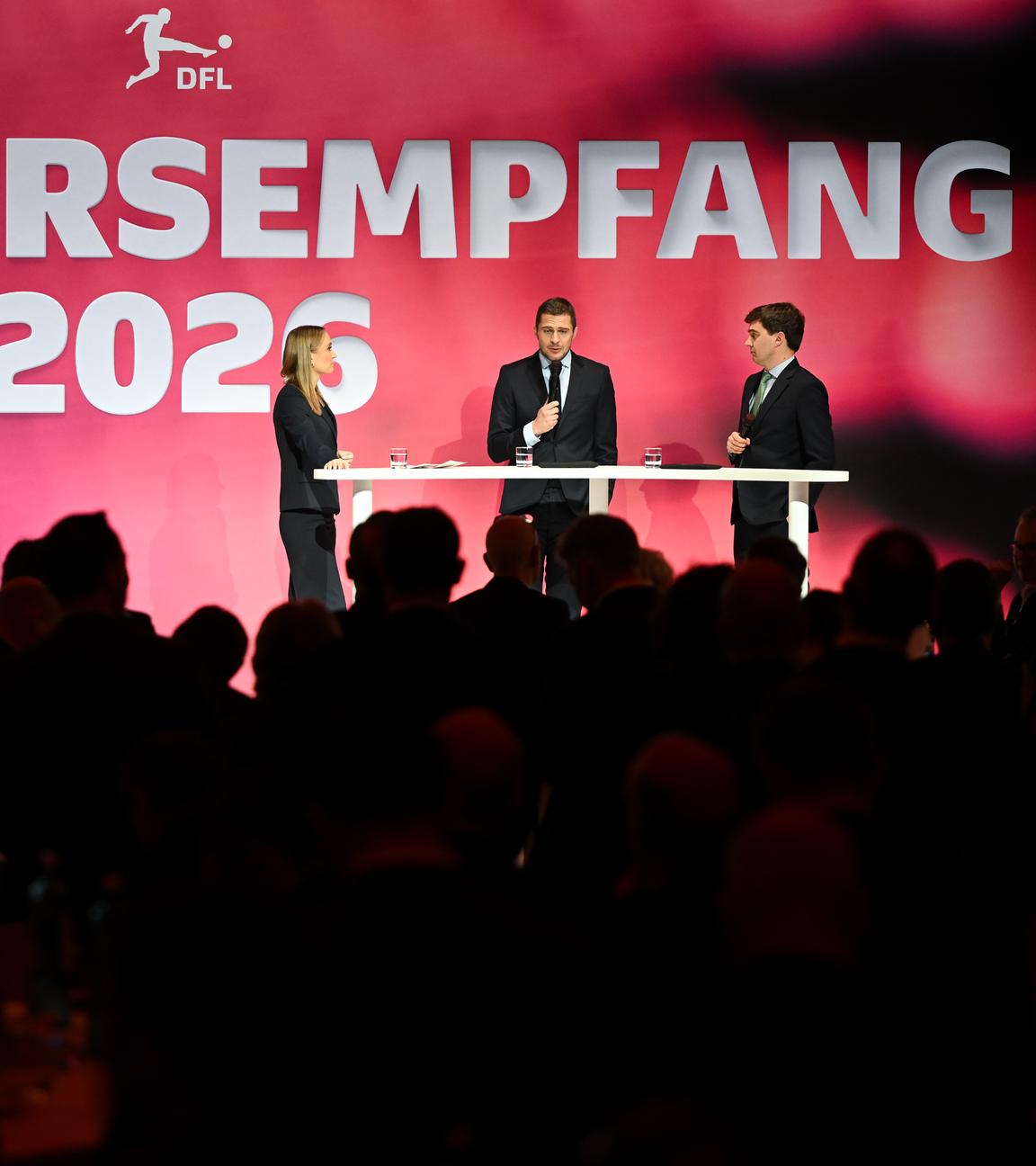 Steffen Merkel (hinten r) und Marc Lenz (hinten M), beide Geschäftsführer der DFL GmbH, sprechen auf dem Neujahrsempfang der DFL.