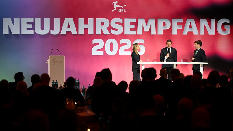 Steffen Merkel (hinten r) und Marc Lenz (hinten M), beide Geschäftsführer der DFL GmbH, sprechen auf dem Neujahrsempfang der DFL.