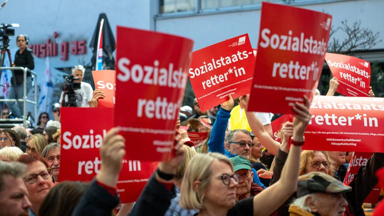 Menschen halten am Kornmarkt in Nürnberg Schilder mit der Aufschrift "Sozialstaatretter*in" hoch.