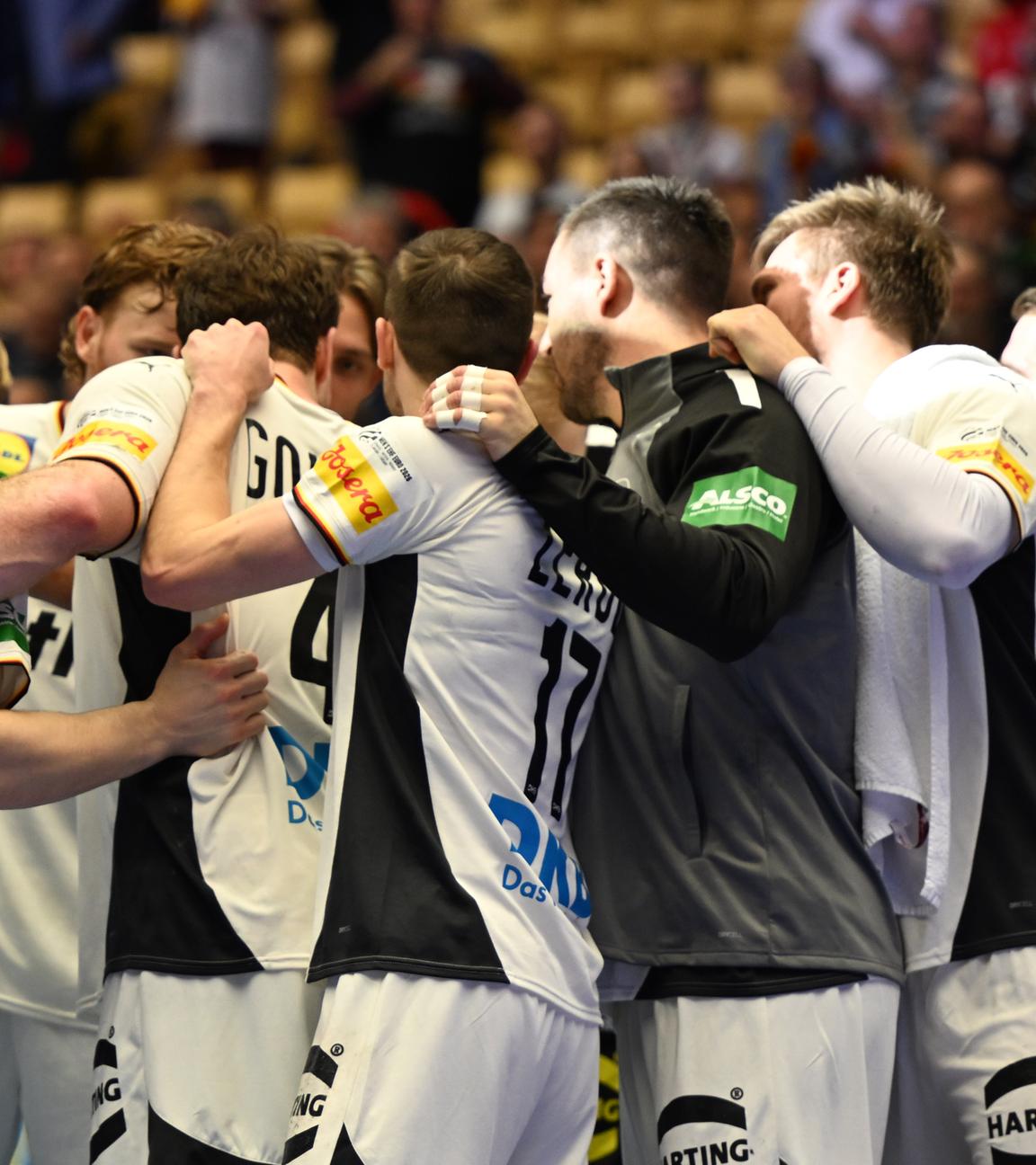 Die deutschen Spieler feiern ihren Sieg gegen das österreichische Handballteam.