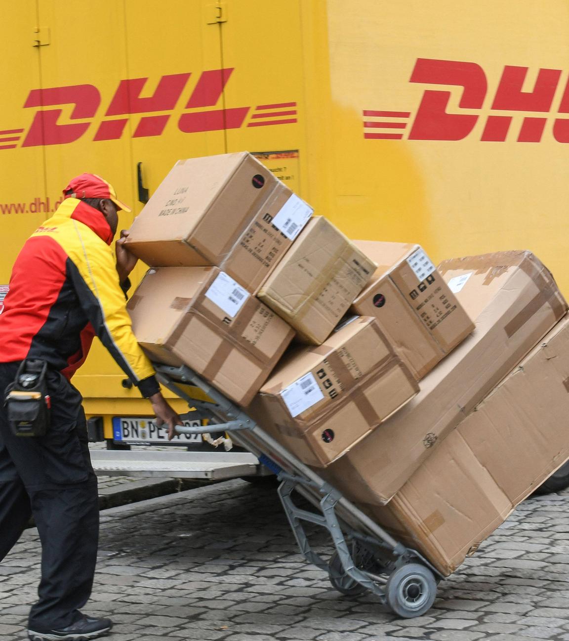 Paketzusteller von DHL bei Auslieferung von Paketen