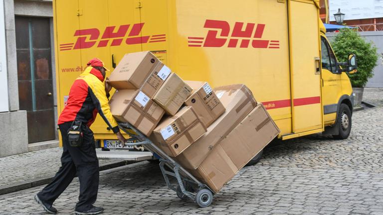 Paketzusteller von DHL bei Auslieferung von Paketen