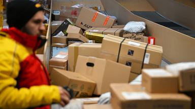 Symbolbild: : Ein Paketbote holt in einer Zustellbasis von DHL