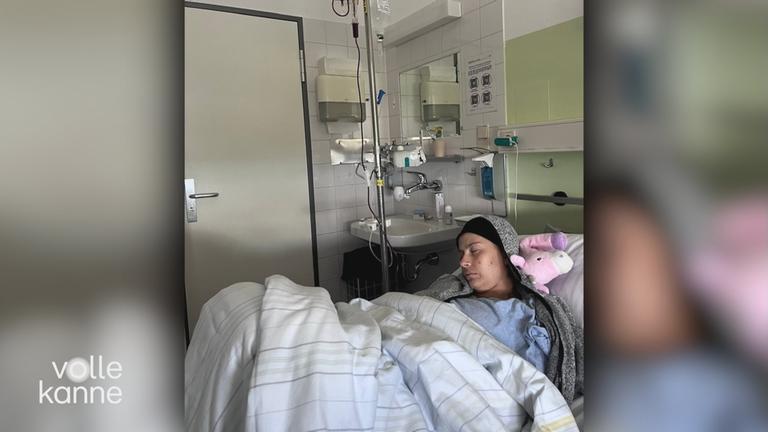 Junge Frau liegt schwer krank mit Krebs im Bett eines Krankenhauses