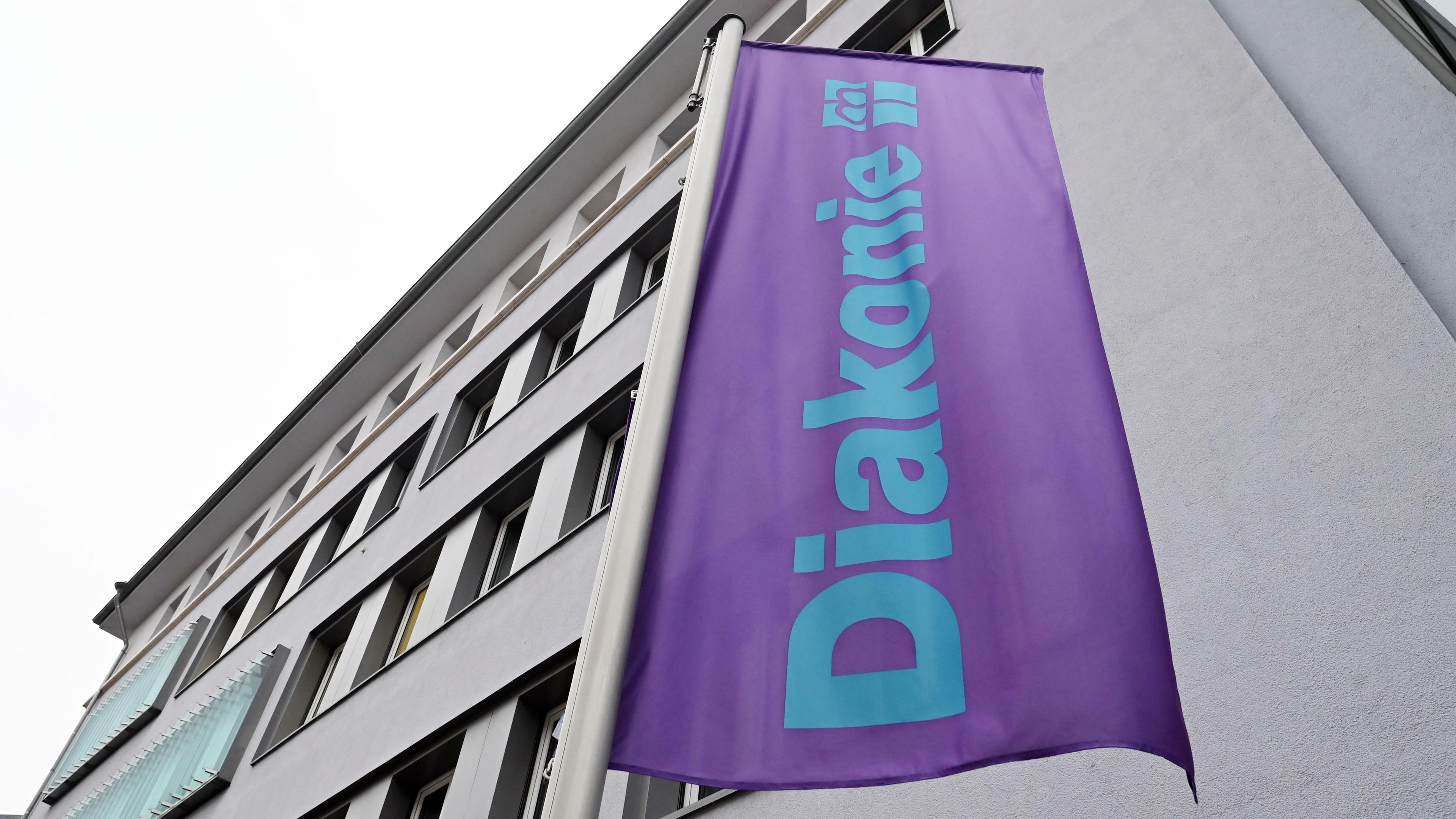 Eine Fahne der Diakonie, aufgenommen vor einem Haus der Diakonie in Karlsruhe.