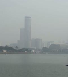 Eine Panorama-Aufnahme von Singapur, in der die Stadt von Nebel durchzogen wird.