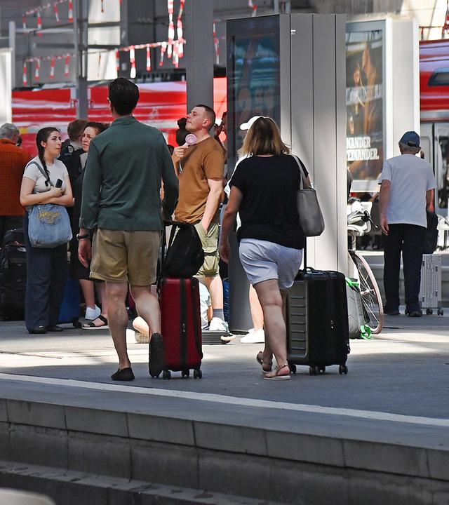 Bahnreisende sind am Gleis im Hauptbahnhof München zu sehen.