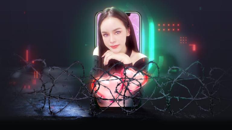 Frau vor Drahtzaun, schaut aus Handy heraus