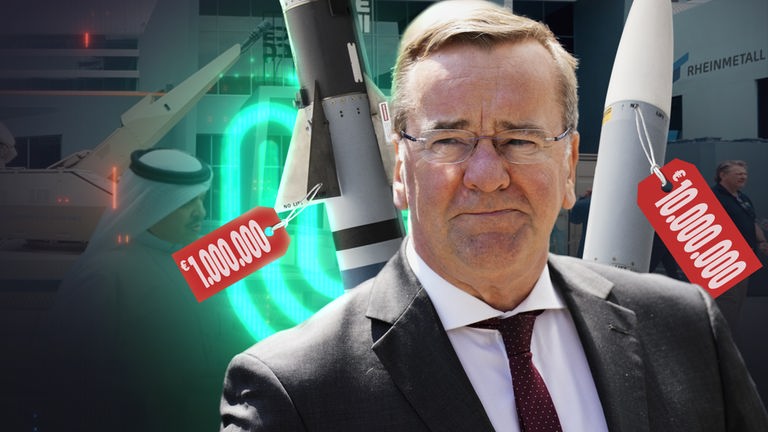 Boris Pistorius vor zwei Raketen, an denen rote Preisschilder hängen.