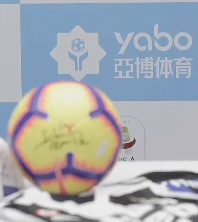 Das Logo von Yabo auf einer blau-weißen Wand, im Vordergrund liegt ein Fußball.