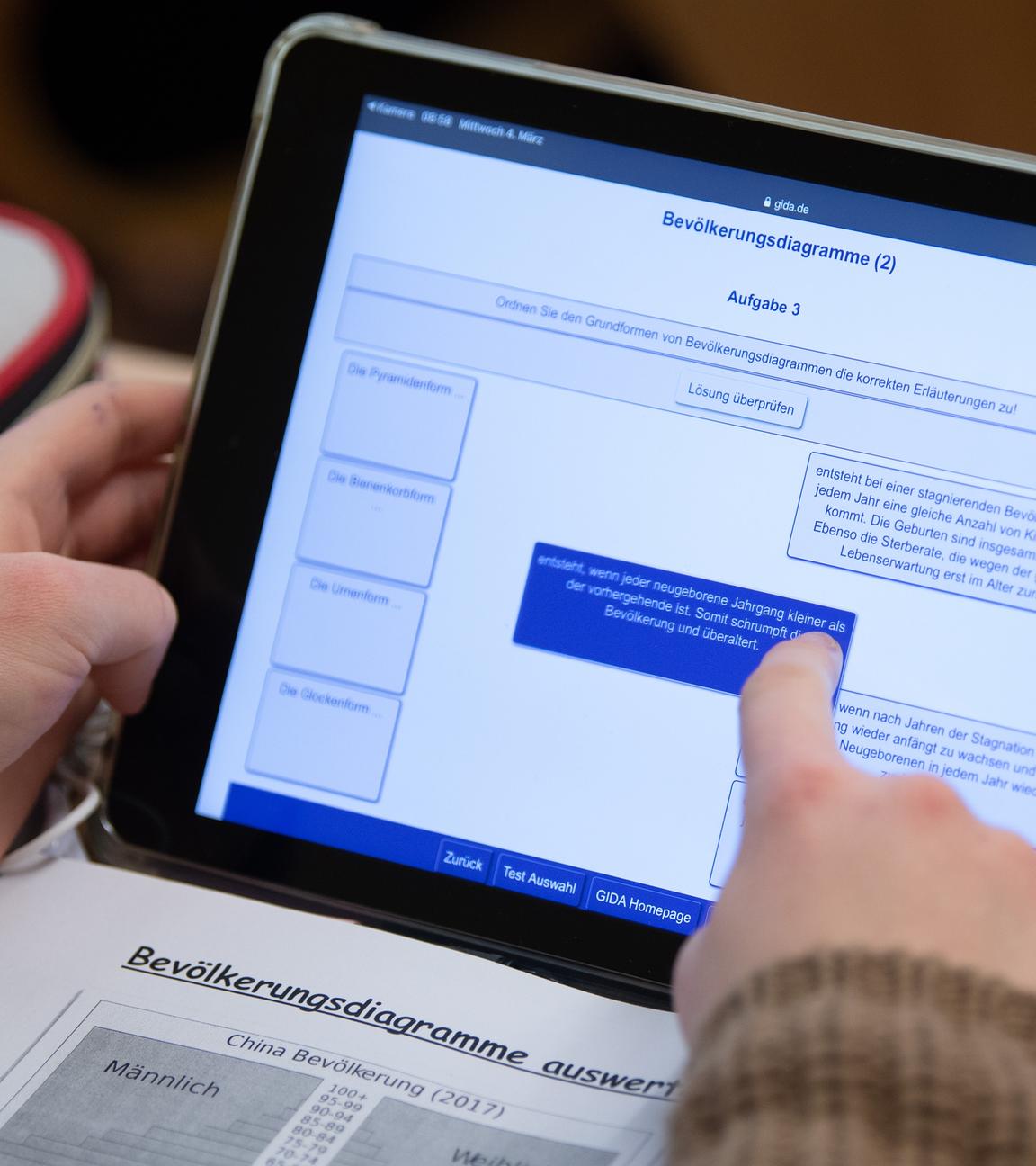 Eine Schülerin einer 9. Klasse arbeitet während eines Presserundgangs in einem Klassenzimmer einer Oberschule mit ihrem iPad im Unterricht.