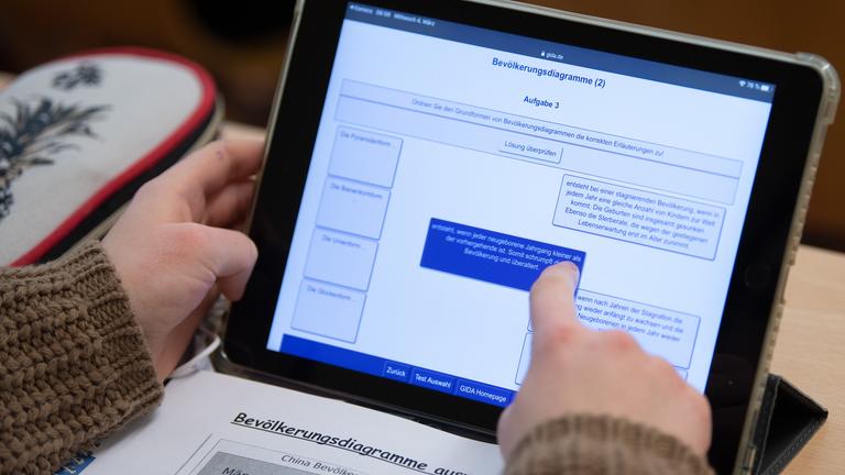 Eine Schülerin einer 9. Klasse arbeitet während eines Presserundgangs in einem Klassenzimmer einer Oberschule mit ihrem iPad im Unterricht.