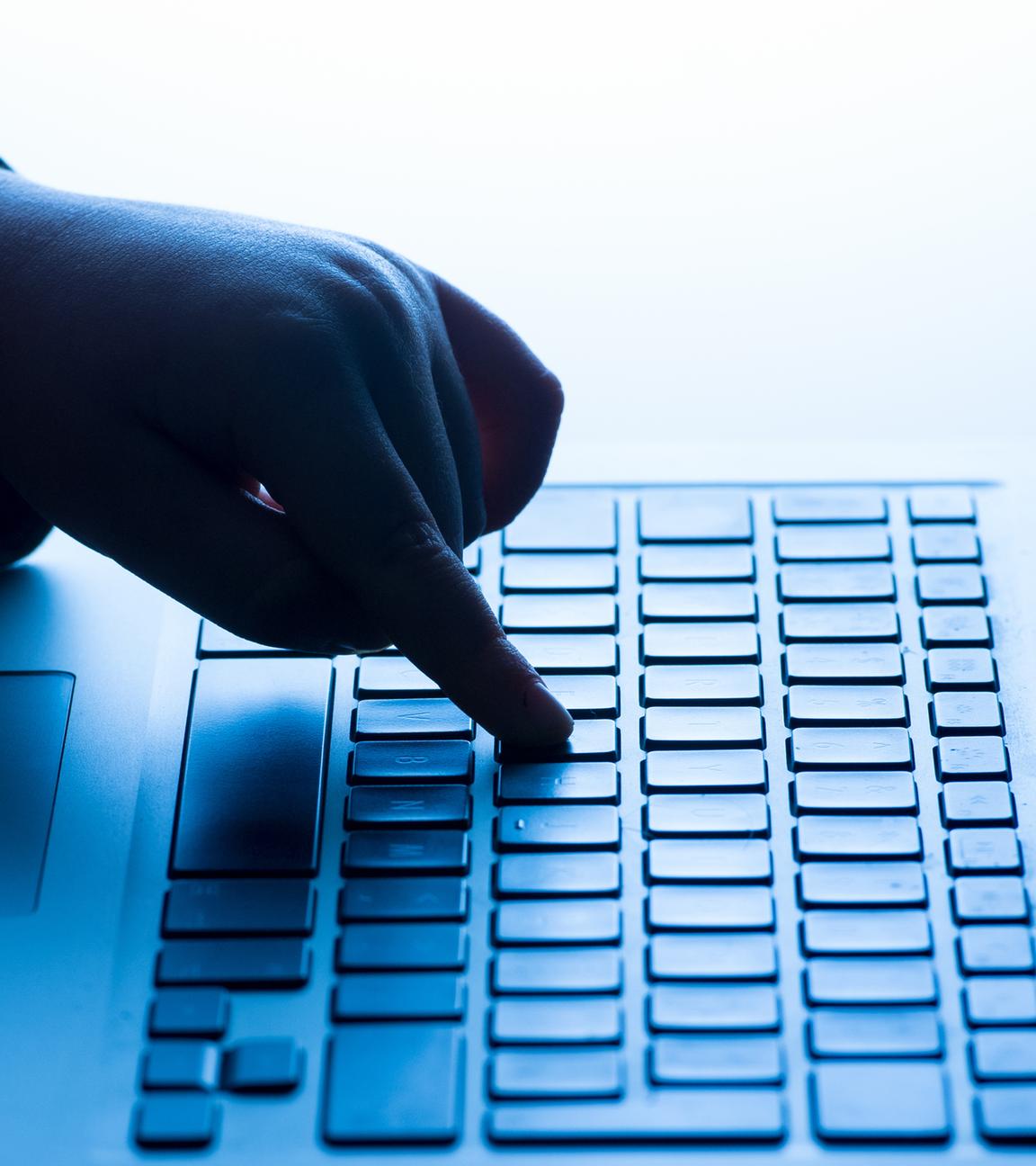 Symbolbild:  Ein Kind benutzt die Tastatur eines Laptops. 