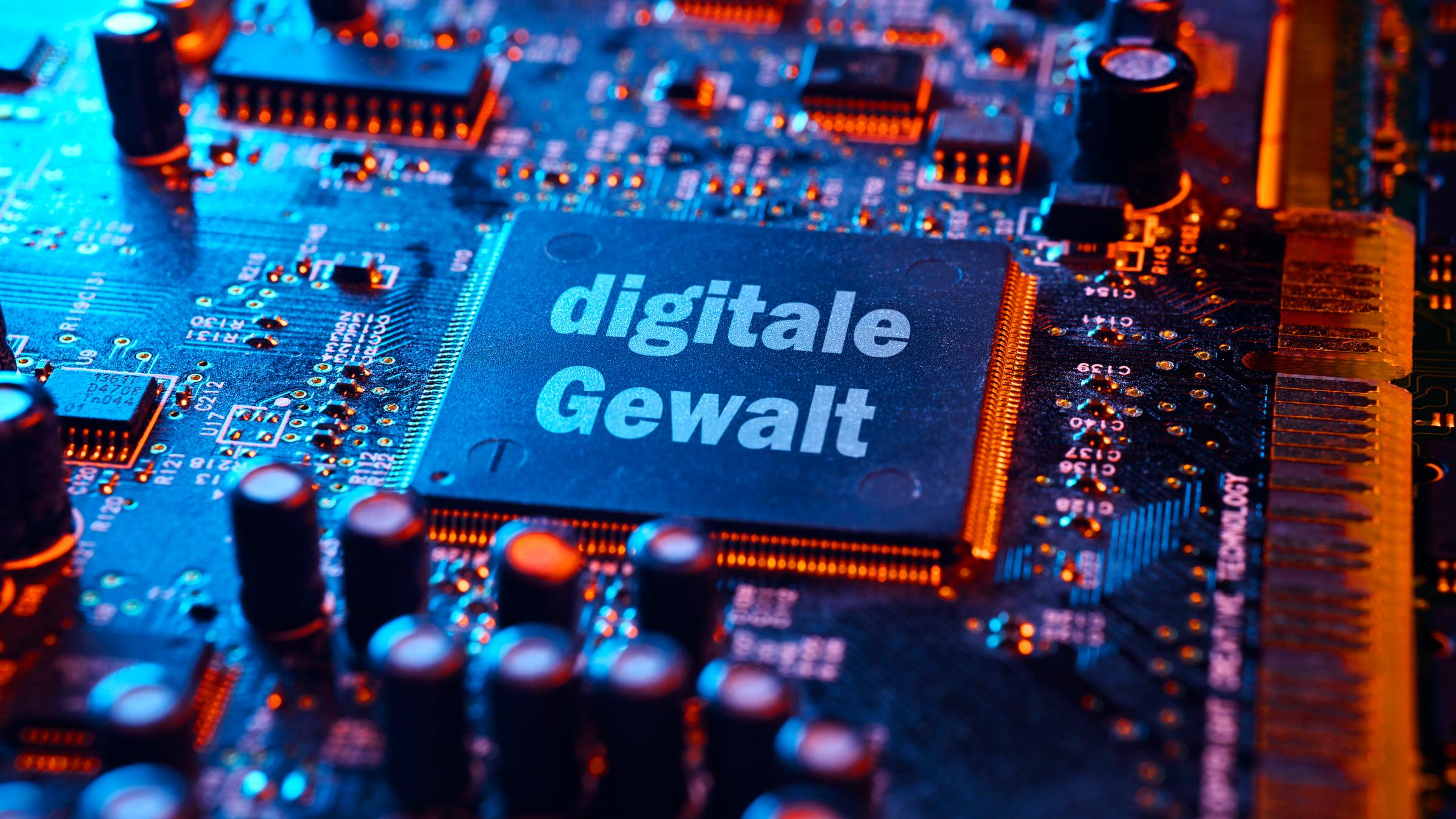 Ein Mikrochip mit Aufschrift digitale Gewalt auf einem Mainboard.