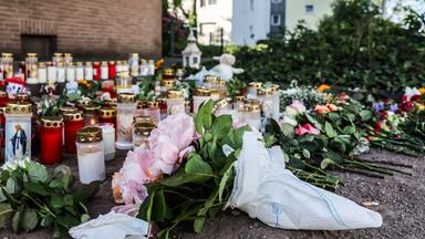 Blumen und Kerzen liegen am Unfallort.