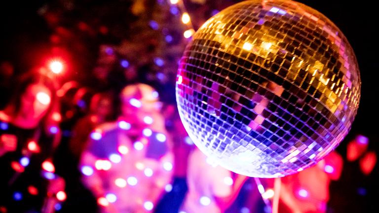 Eine Diskokugel in einer vollen Diskothek