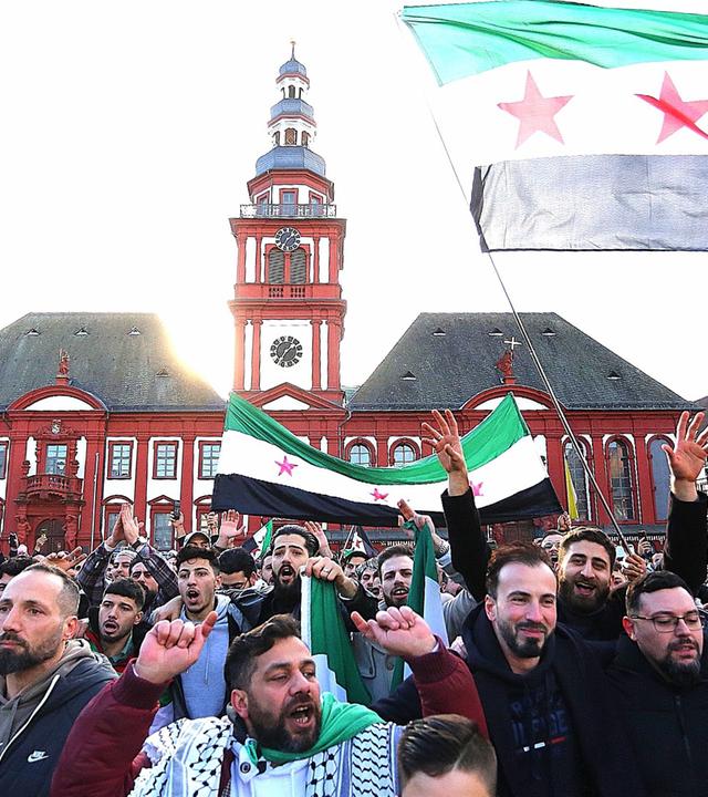 08.12.2024, Mannheim: Syrer feiern in Mannheim auf dem Marktplatz, nach dem Sturz des bisherigen syrischen Machthabers al-Assad.