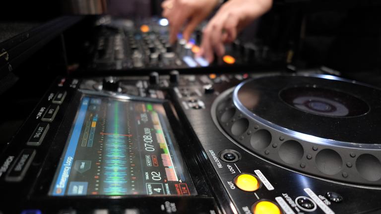 Ein DJ spielt in einer Halle der Leipziger Messe.