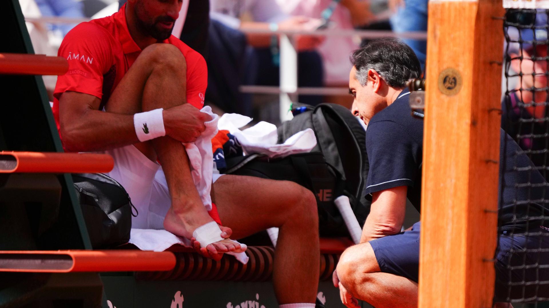 Novak Djokovic wird während eines Spiels bei den French Open am Fuß behandelt