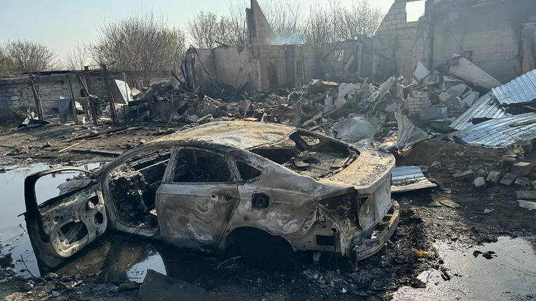 Zerstörung in der Ukraine, im Vordergrund ein ausgebranntes Auto