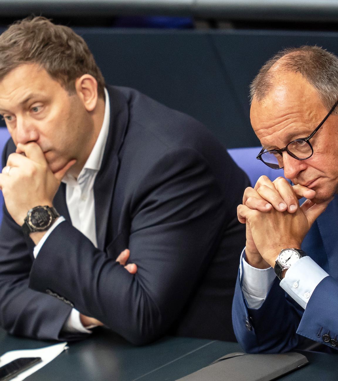 Bundesinnenminister Alexander Dobrindt, Bundesfinanzminister Lars Klingbeil und Bundeskanzler Friedrich Merz verfolgen eine Debatte im Bundestag am 11.07.2025.