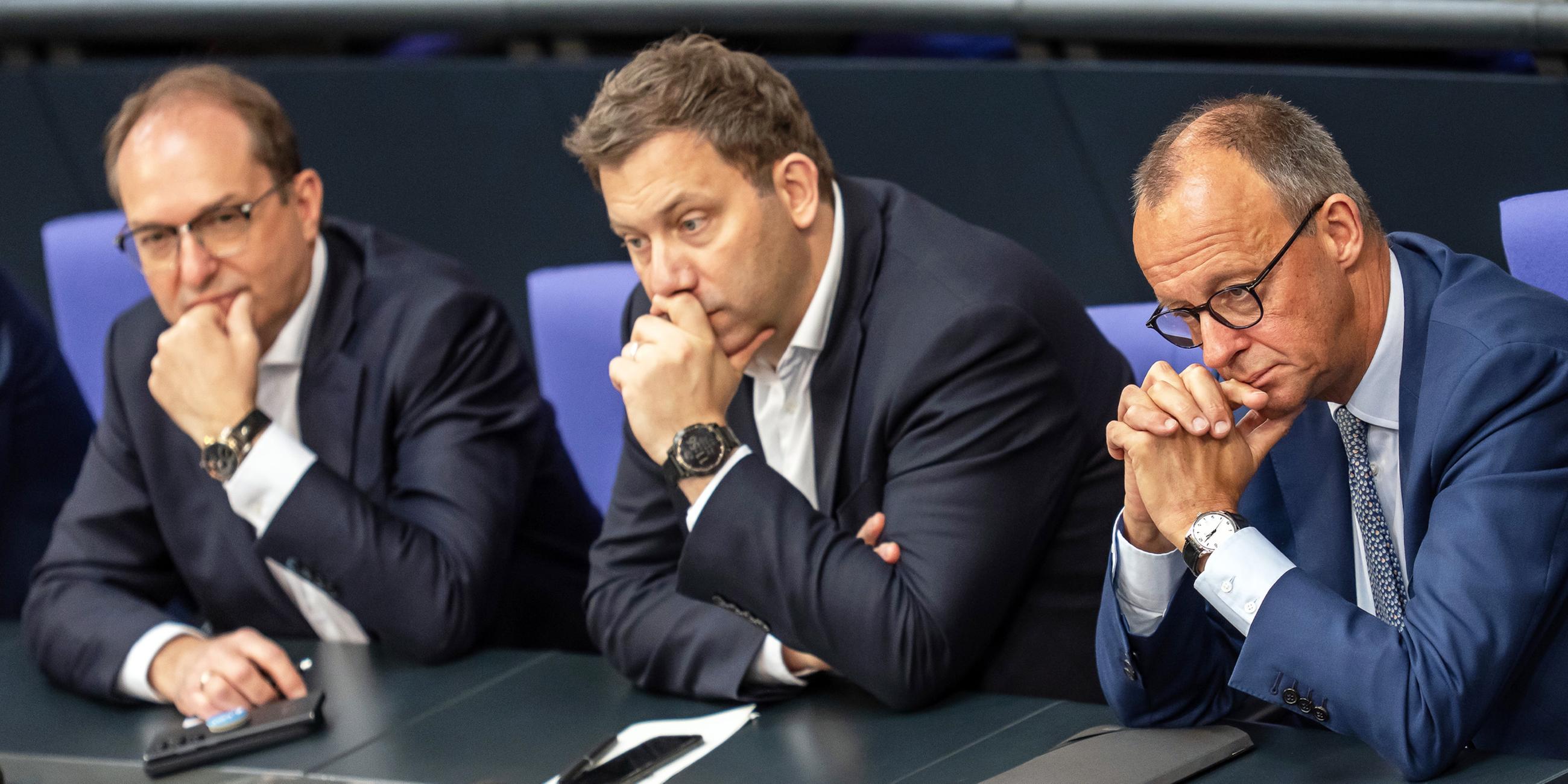 Bundesinnenminister Alexander Dobrindt, Bundesfinanzminister Lars Klingbeil und Bundeskanzler Friedrich Merz verfolgen eine Debatte im Bundestag am 11.07.2025.