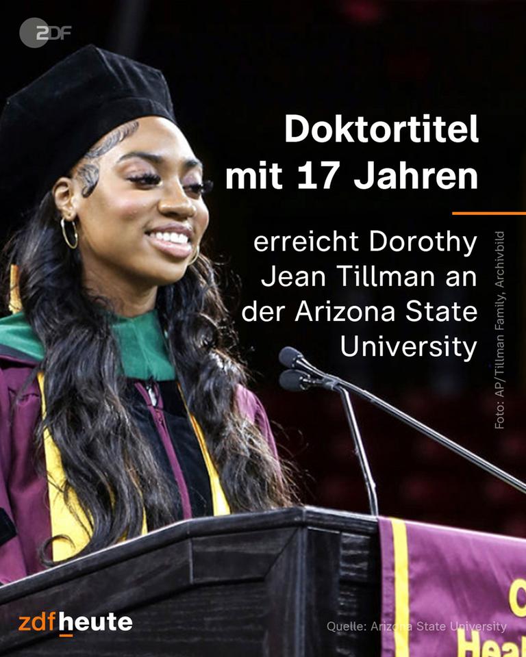 Eine junge Frau steht mit einer Robe an einem Pult
