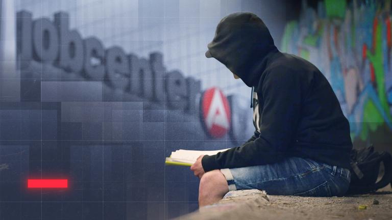 Mann mit schwarzem Hoodie sitzt vor einem Gebäude mit "jobcenter"-Schriftzug