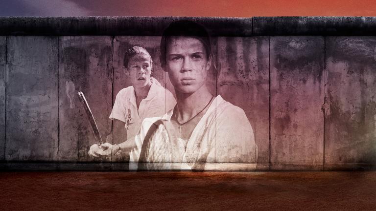 Ein Stück der Berliner Mauer, auf die die Gesichter von zwei Tennis-Spielern projiziert sind.