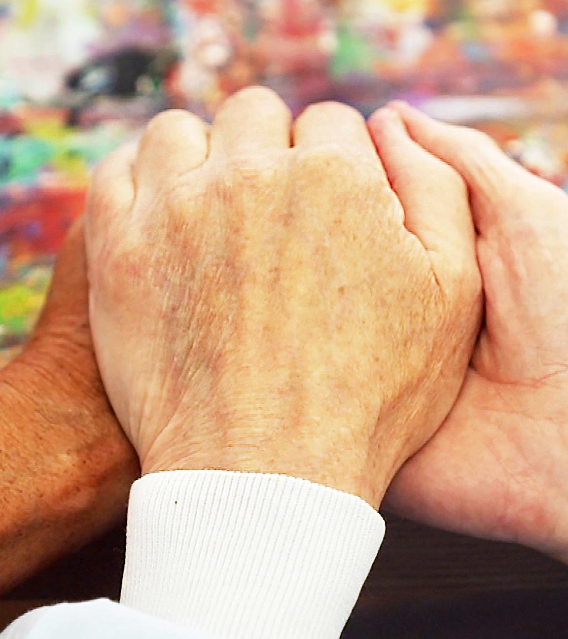 Eine Hand wird gehalten auf einer Palliativstation