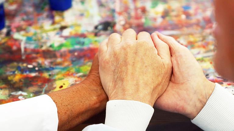 Eine Hand wird gehalten auf einer Palliativstation