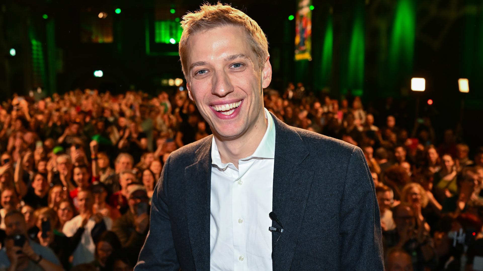 Dominik Krause steht vor einer Menge auf der Bühne.