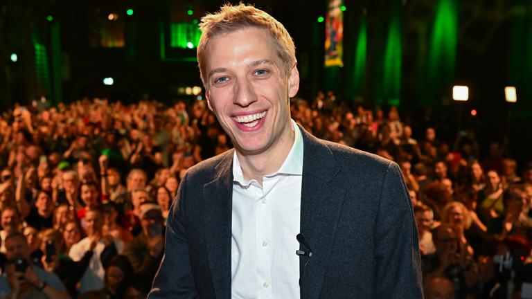 Dominik Krause steht vor einer Menge auf der Bühne.