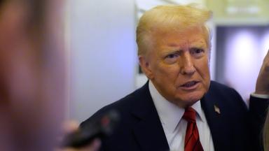 Donald Trump spricht zu Reportern an Bord der Air Force One.
