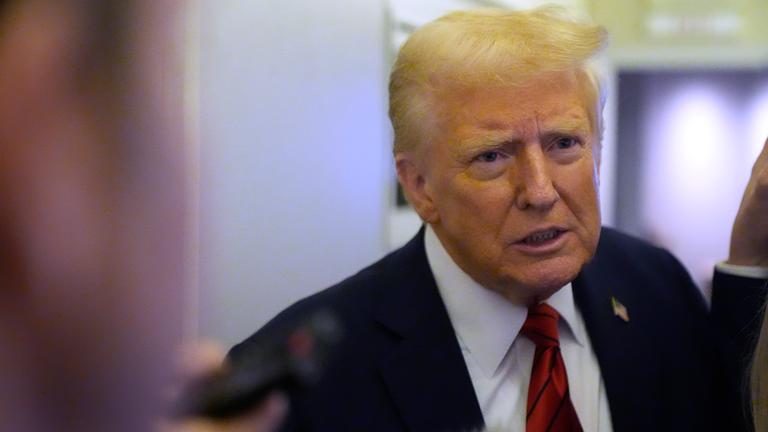 Donald Trump spricht zu Reportern an Bord der Air Force One.