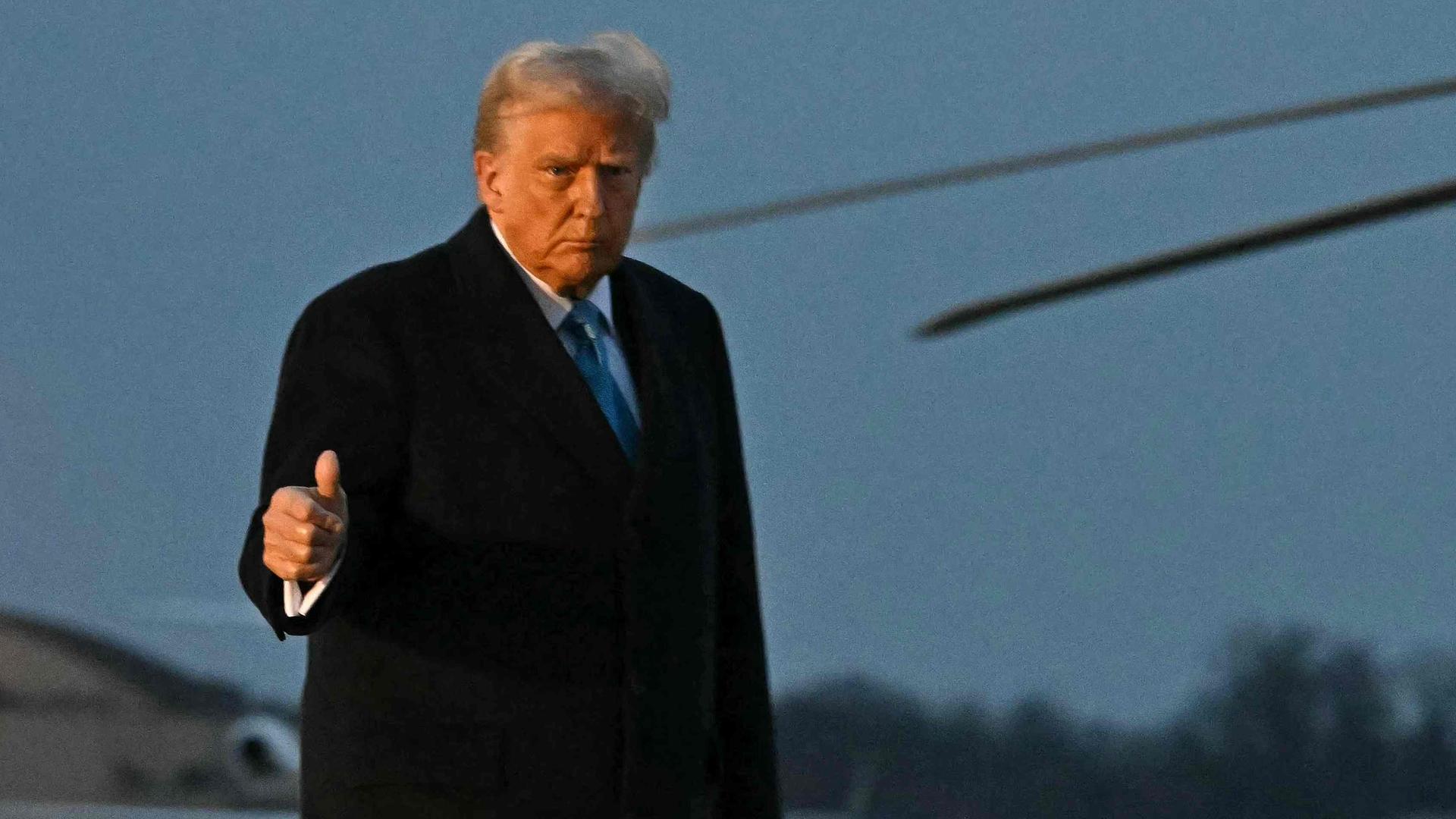 Donald Trump auf einem Flugplatz, zeigt einen Daumen hoch.