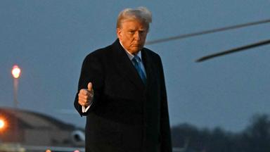 Donald Trump auf einem Flugplatz, zeigt einen Daumen hoch.