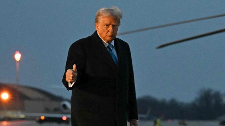 Donald Trump auf einem Flugplatz, zeigt einen Daumen hoch.