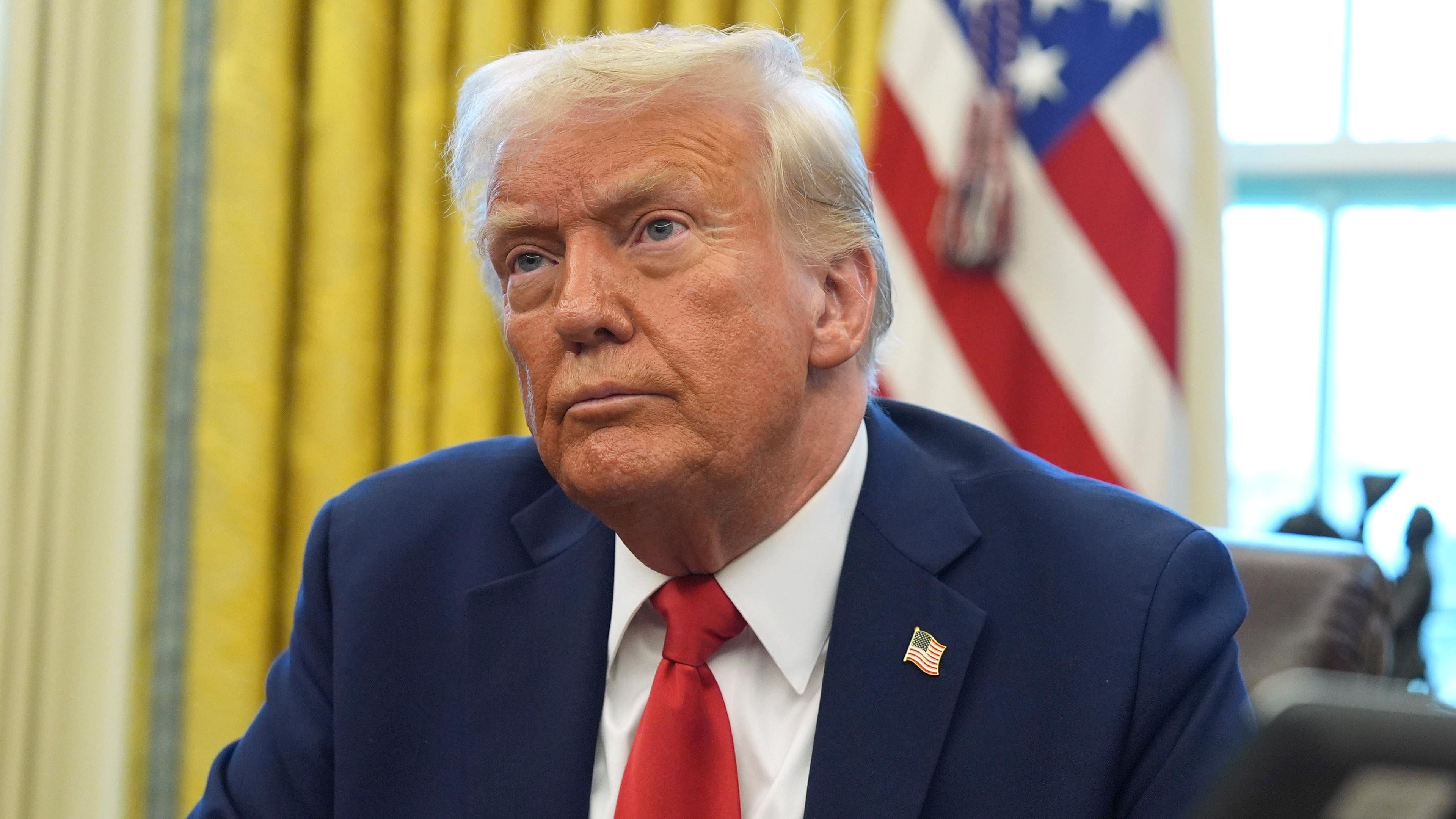 Donald Trump sitzt am Schreibtisch im Oval Office des Weißen Hauses. 