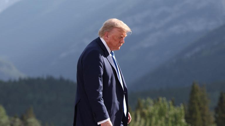 US-Präsident Donald Trump läuft vor einer Landschaft.