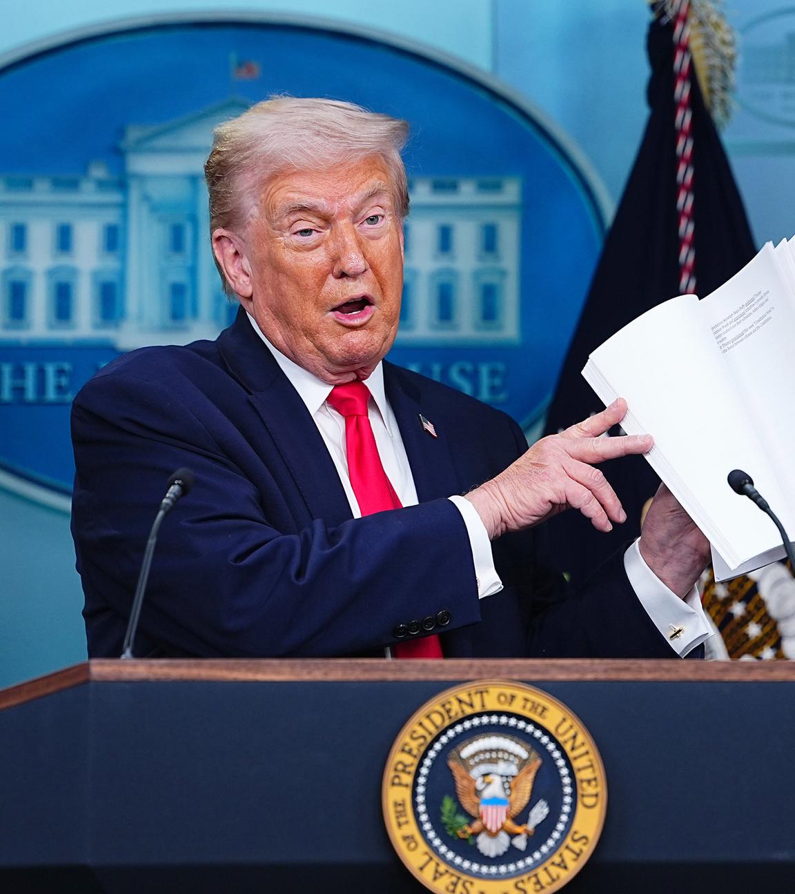 US-Präsident Donald Trump blättert in einem Buch über die Erfolge seiner Regierung, aufgenommen am 20.01.2026 in Washington (USA)